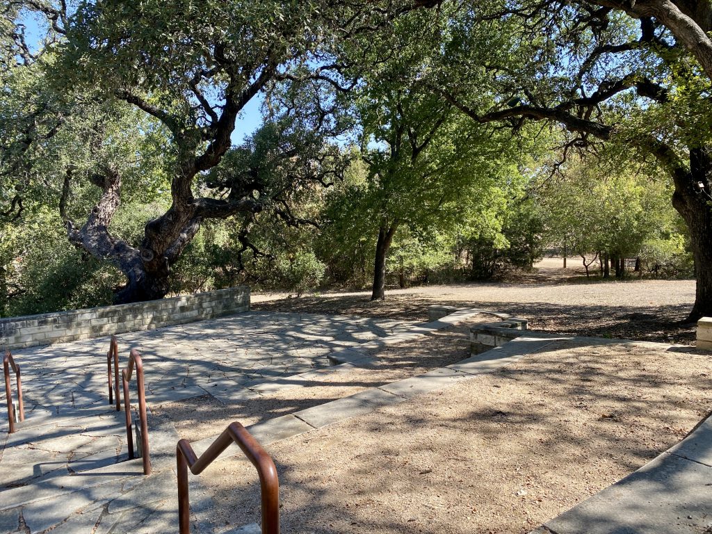 Stone paths and steps wind beneath mature oak trees.